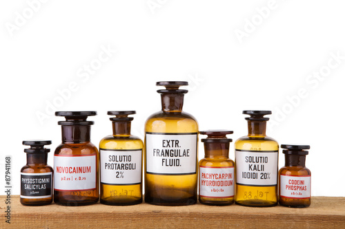 Various vintage pharmacy bottles on wooden board