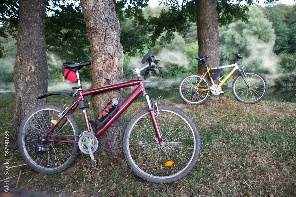 Mountain bikes on the bank of the river in mist Mountain bikes on the bank of the river in mist