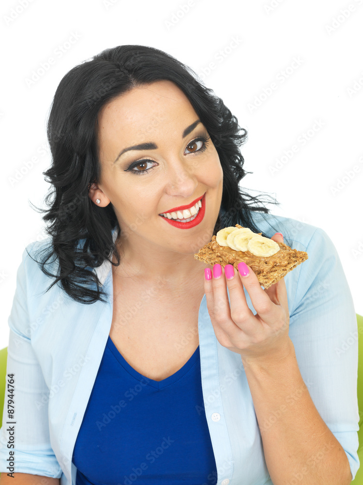 Young Woman Eating a Cracker with Peanut Butter and Sliced Banana Young Woman Eating a Cracker with Peanut Butter and Sliced Banana
