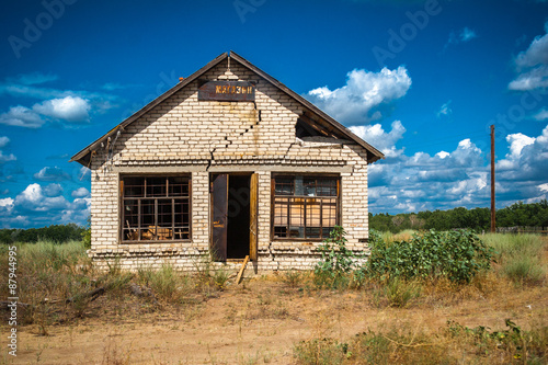 Сracked abandoned building with close up of large vertical crack on exterior of brick building.