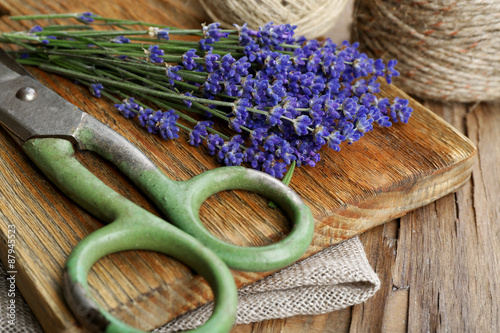 Fresh lavender with rope and scissors on wooden cutting board, closeup