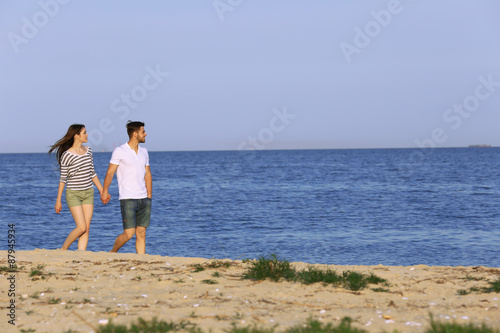 Young couple walking on beach © Africa Studio