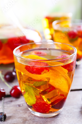 Punch with berries in glassware on wooden table, closeup