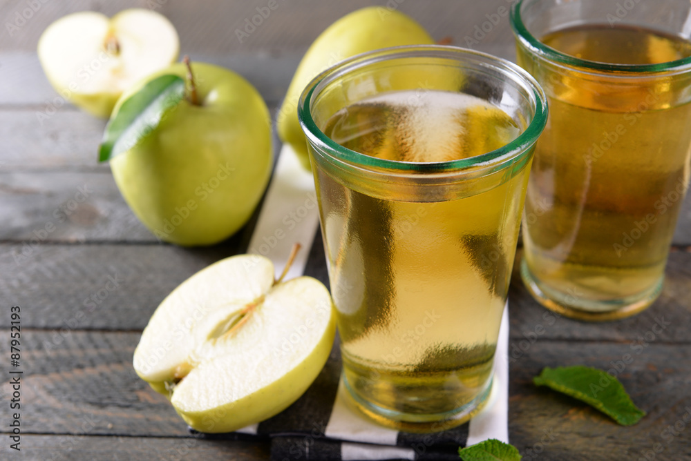 Glasses of apple juice on wooden table, closeup Glasses of apple juice on wooden table, closeup
