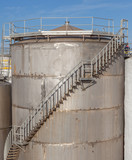 The huge petrol oil tanks with stairs exterior in refinery indus