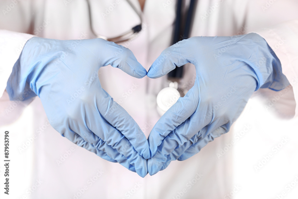 Fototapeta premium Doctor hands in gloves making shape of heart, closeup