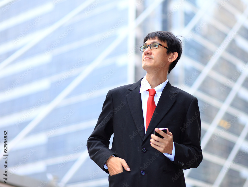Portrait of young businessman wearing glasses and using smartpho Portrait of young businessman wearing glasses and using smartpho