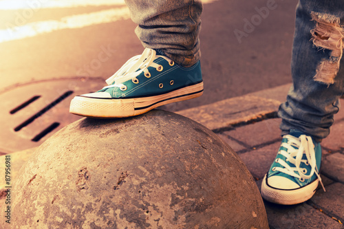 Blue sneakers, teenager feet in gumshoes, toned