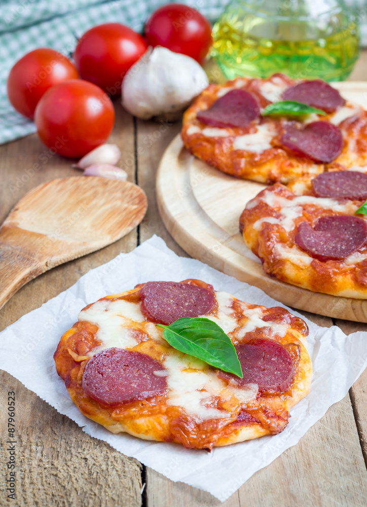 Homemade mini pepperoni pizza on a wooden board Homemade mini pepperoni pizza on a wooden board