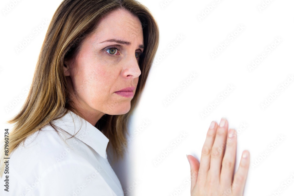 Depressed businesswoman leaning against a white wall Depressed businesswoman leaning against a white wall