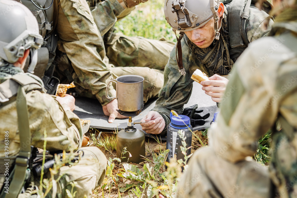 rangers are heated food on the fire and eat in the forest foto de Stock