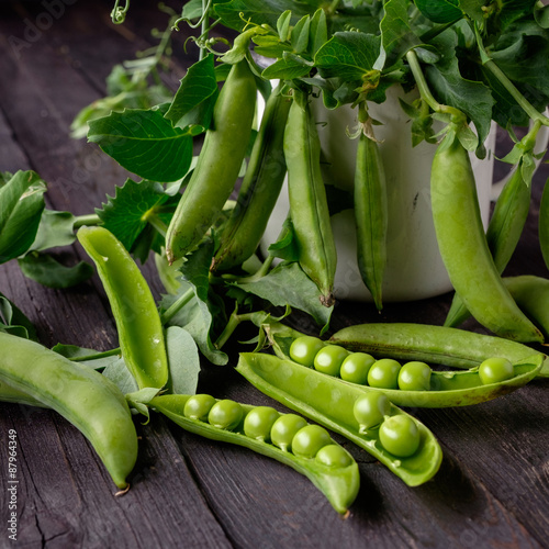 Ripe Green peas on wooden table.