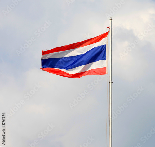 Image of waving Thai flag of Thailand with blue sky background.