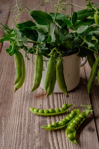 Ripe Green peas on wooden table.