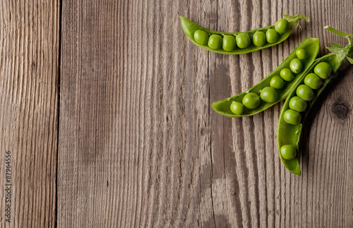 Ripe Green peas on wooden table.