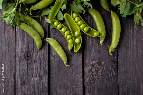 Ripe Green peas on wooden table.