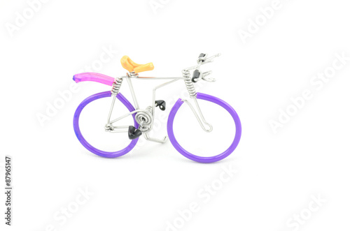 Fototapeta Naklejka Na Ścianę i Meble -  purple wired bicycle miniature placed from left to right isolated white background