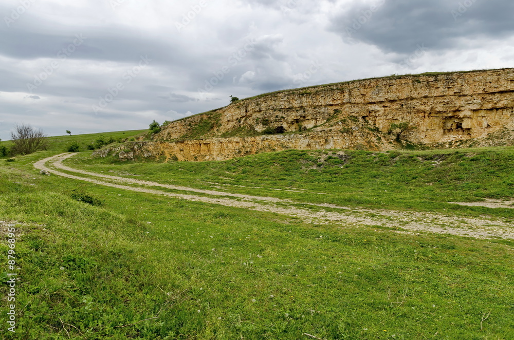General view toward crag of sedimentary rock in the field, Ludogorie, Bulgaria  