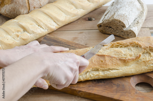 female hands slicing bread