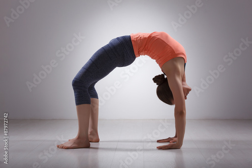 Beautiful sporty fit yogi girl practices yoga asana chakrasana photo