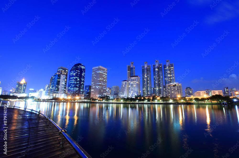 Naklejka premium Pejzaż widok nowoczesnych budynków w ogrodzie Benjakitti o zmierzchu