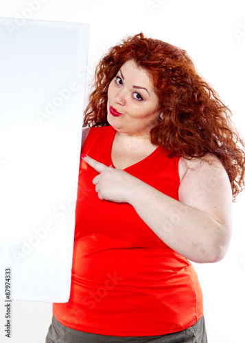 the beautiful fat, big sensuality woman with red lipstick and with red t-shirts holding the white bilboard on the white background. When she hold bilboard the fixed with big finger point up.