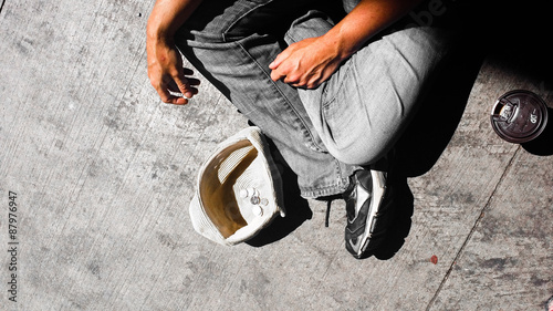 Male money beggar with hat and coffee cup photo
