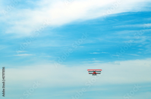 red triplane flies in the blue sky