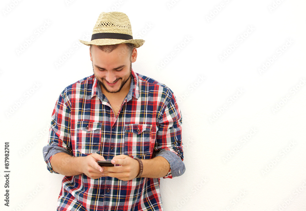 Trendy happy guy with hat looking at mobile phone Trendy happy guy with hat looking at mobile phone