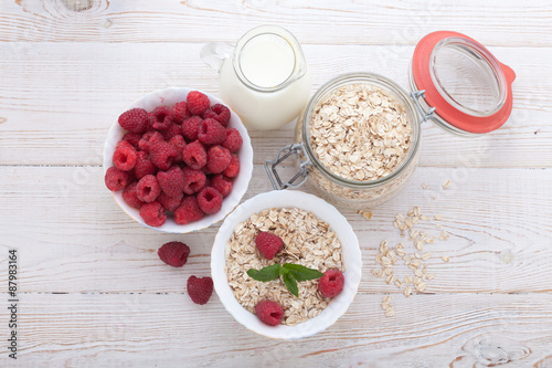 Berries, fruit, milk and muesli Ingredients for healthy breakfast on wooden table
