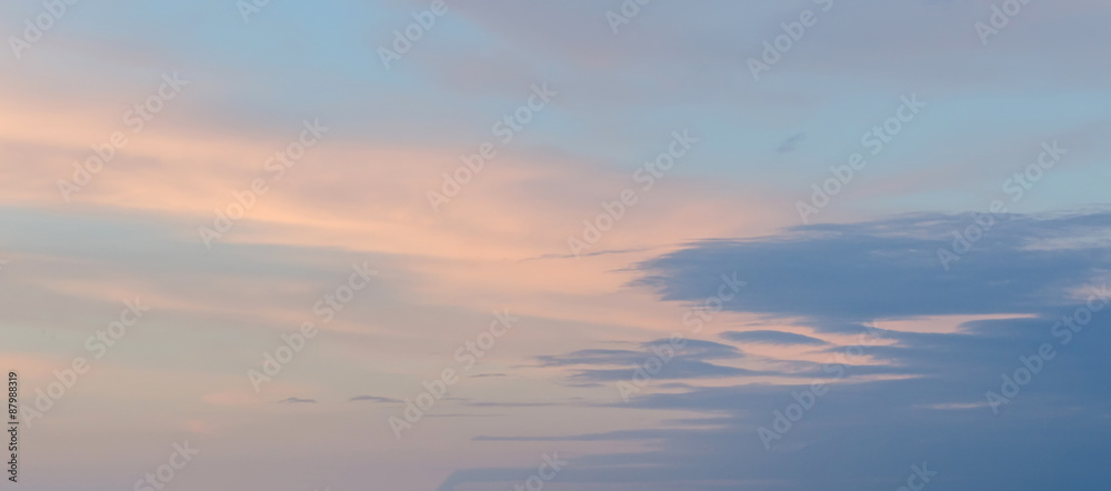 Fototapeta premium Blue sky with fluffy colored clouds, ray of lights, sunset, dawn.