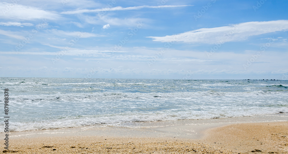 The Black Sea beach with sand and water, blue sky clouds, seaside