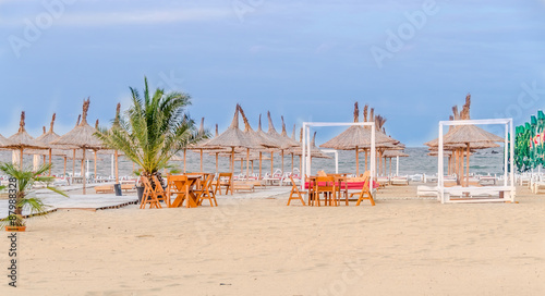 The Black Sea beach, terrace with umbrellas, sand,water and blue sky. photo