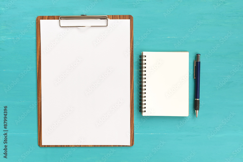 Blank paper and notebook on blue background