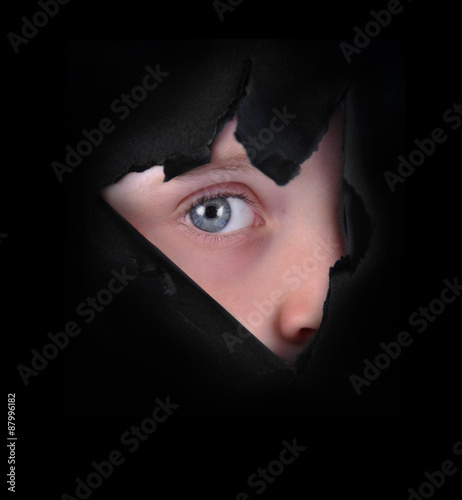 Foto Child Peeking Through Black Paper