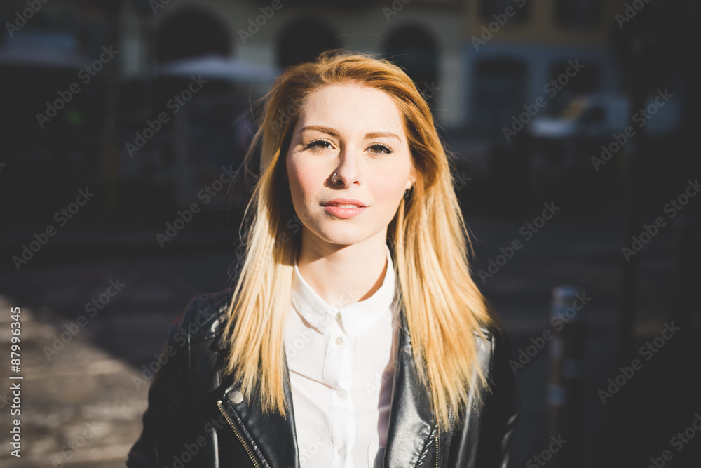 Portrait of young woman standing on street during sunset Portrait of young woman standing on street during sunset