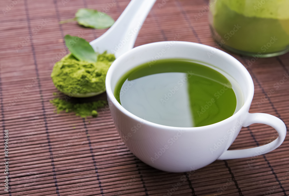 Green tea matcha in a cup on the brown mat Green tea matcha in a cup on the brown mat
