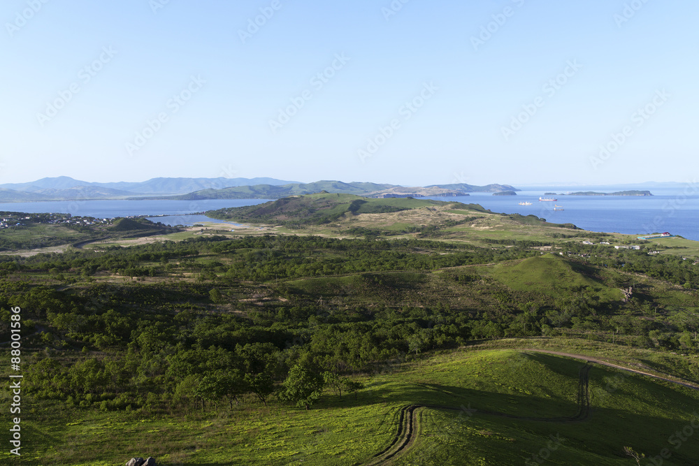 The blue sky, the sea and green hills