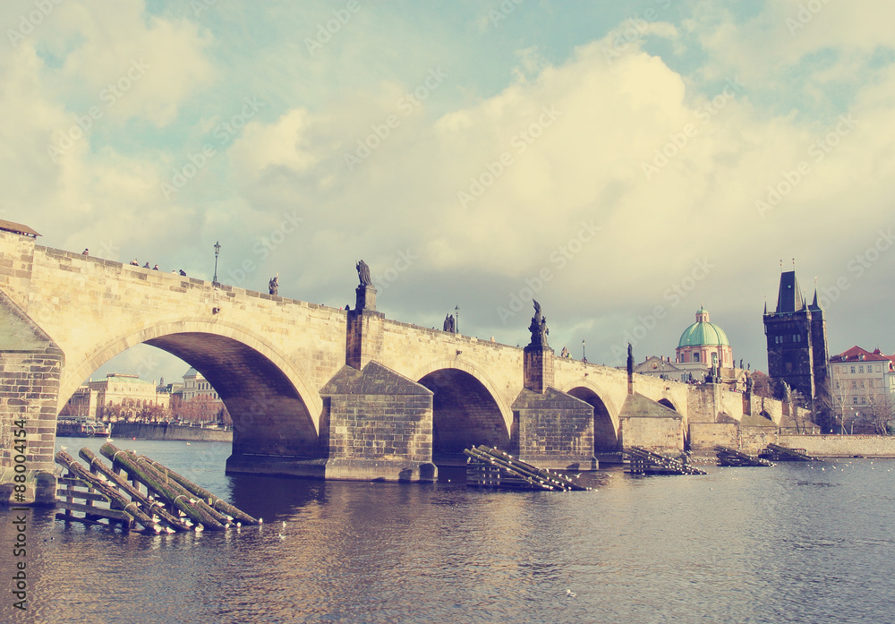 Charles' bridge in Prague on a sunny day. Image filtered in faded, washed out, retro style; nostalgic, vintage travel concept.