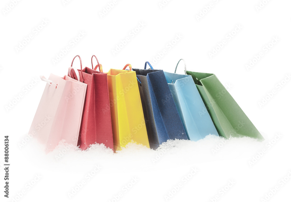 The red, pink, yellow, green and blue gift packages stand on snow, isolated on the white
