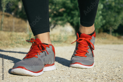 Fototapeta Naklejka Na Ścianę i Meble -  Feet of a woman runner in a sand track