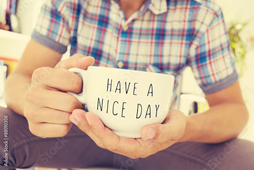 Fotografija young man with a cup with the text have a nice day