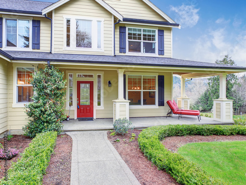 Classic American home with light yellow exterior. © Iriana Shiyan