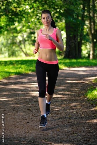 Fototapeta Naklejka Na Ścianę i Meble -  Beautiful woman runner running in city park