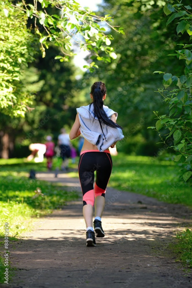 Beautiful woman runner running in city park Beautiful woman runner running in city park