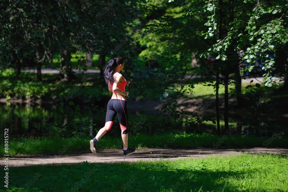 Beautiful woman runner running in city park