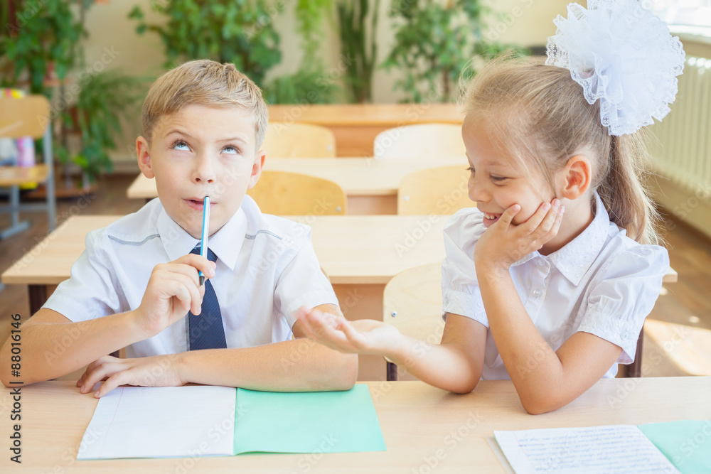 Students or classmates in school classroom sitting together at desk