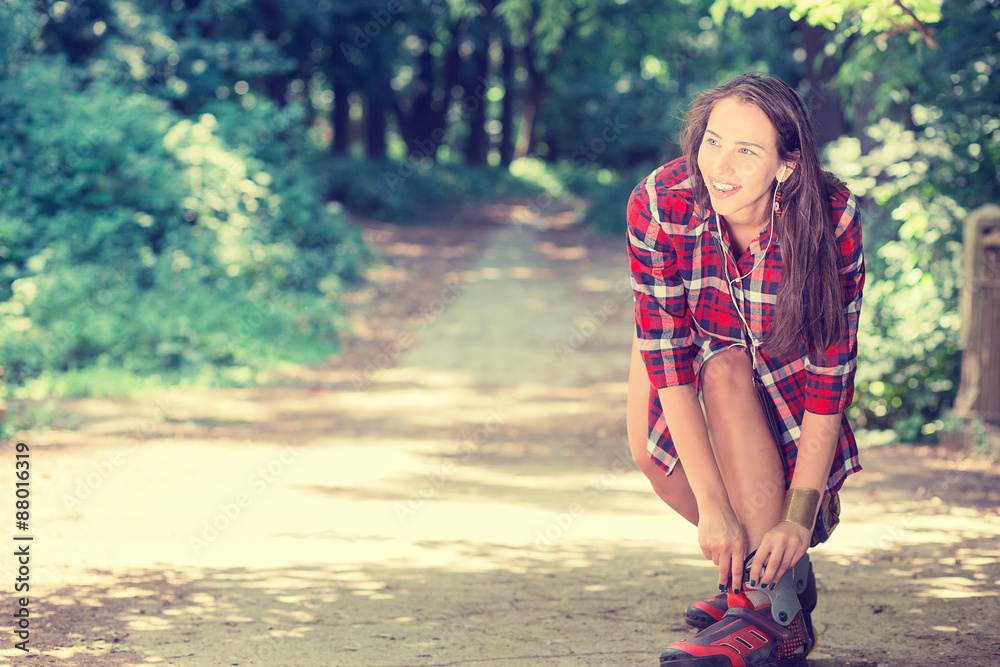 Girl going rollerblading sitting putting on in line skates outdo Girl going rollerblading sitting putting on in line skates outdo