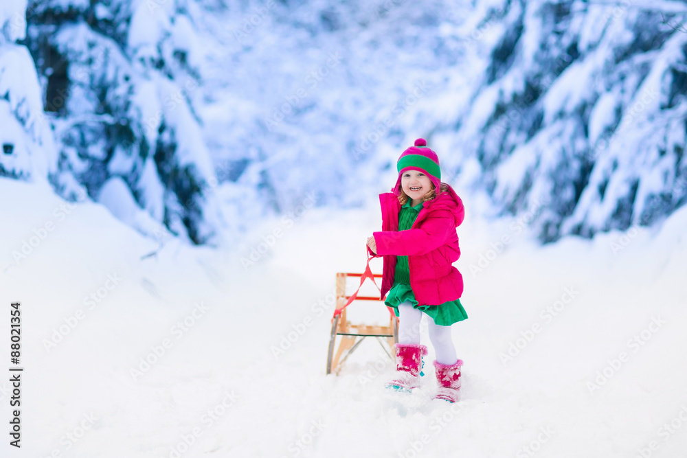 Little girl having fun in snowy winter park