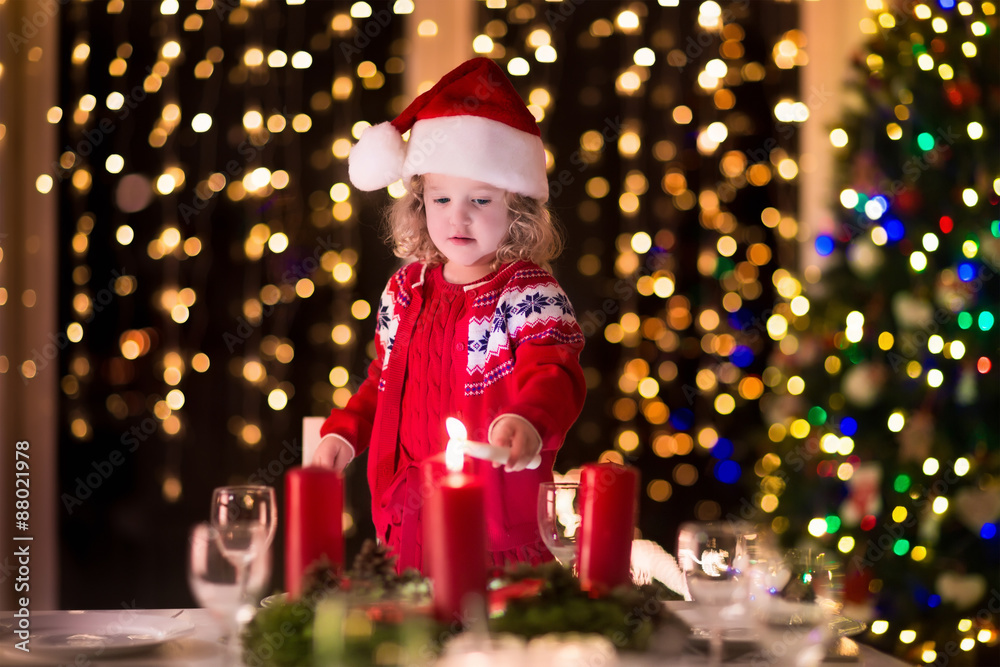 Little girl lighting candles at Christmas dinner Little girl lighting candles at Christmas dinner